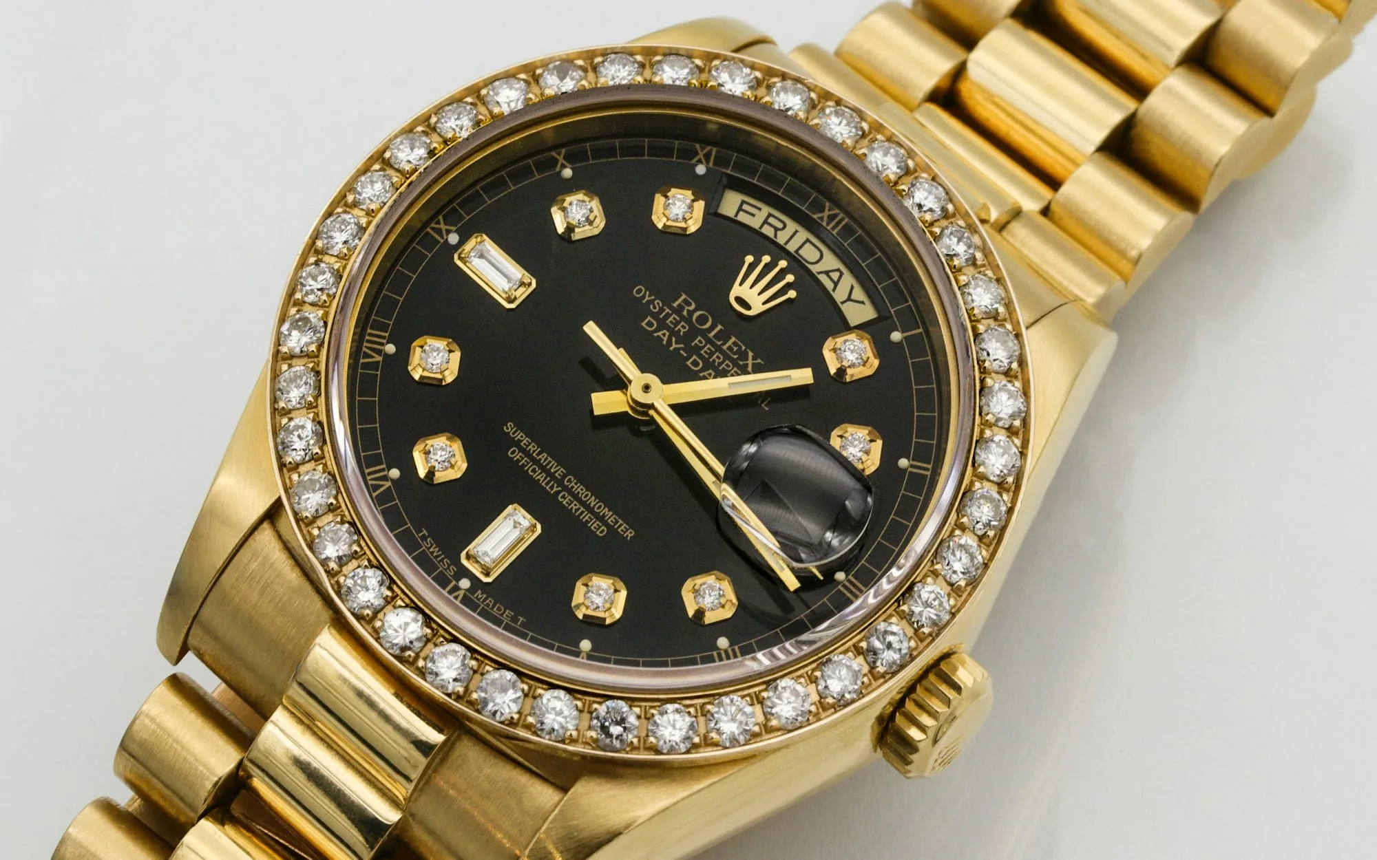 A gold Rolex Day-Date with a diamond bezel