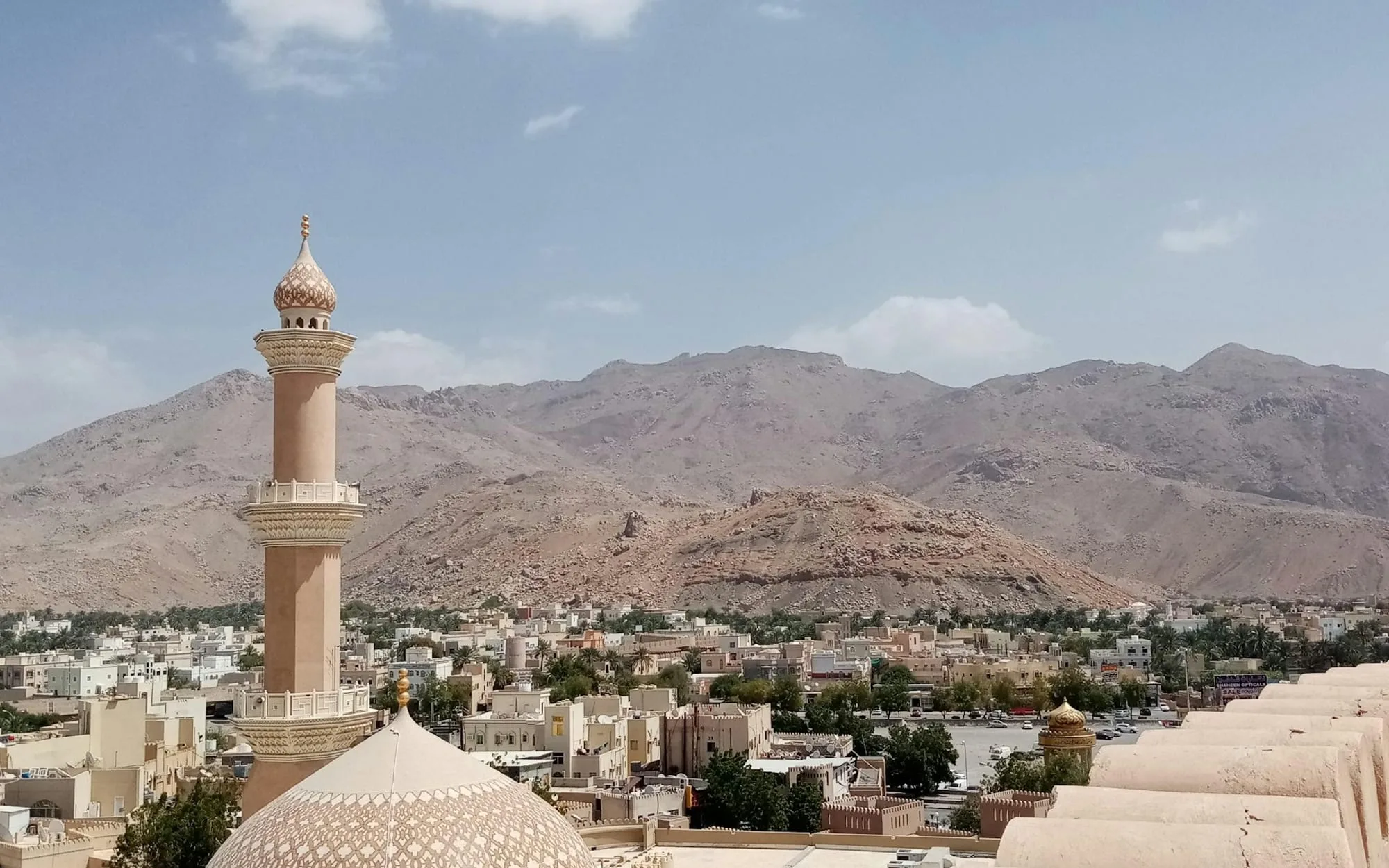 A minaret and the Hajar mountains at Nizwa, Oman