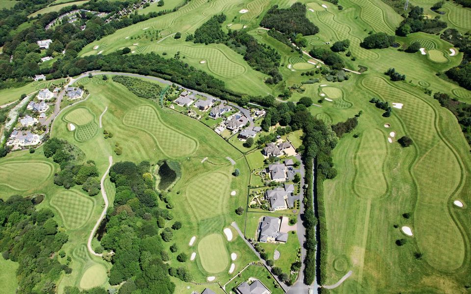 Aerial view of a golf course lined with homes