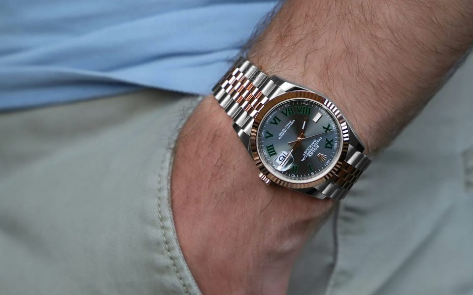 A Rolex Datejust on a wrist beside a trouser pocket
