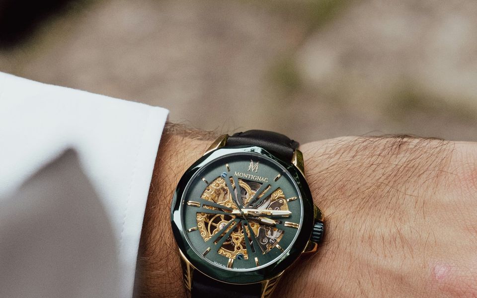A skeletonised watch on a man’s wrist