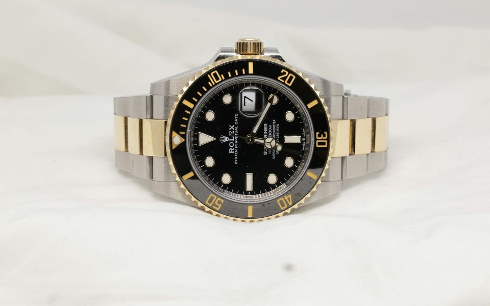 A two-tone Rolex Submariner on a white cloth