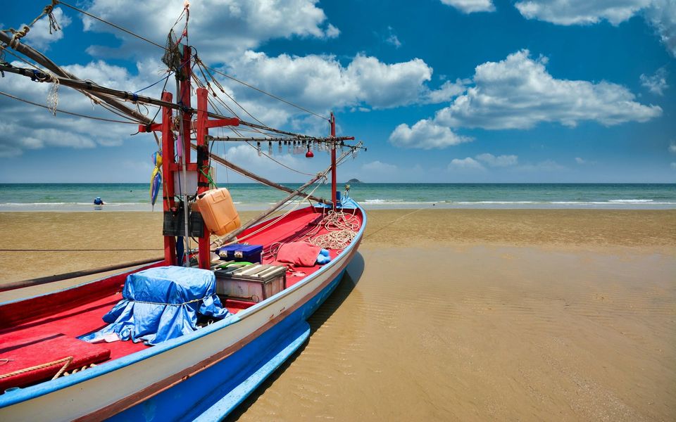 Squid-fishing boat beached at low tide on Hua Hin beach