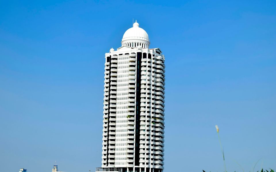 Domed residential condominium tower against a blue sky, Bangkok