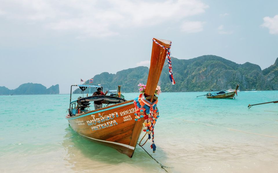 Garlanded longtail boat moored in turquoise water, Phi Phi Islands