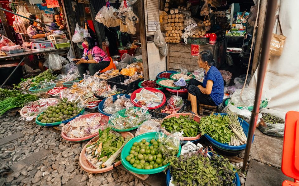 Fresh herbs, limes and chillies in basins at a Thai fresh market