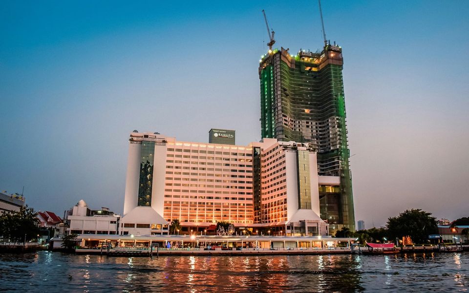Condominium tower under construction with tower cranes beside the Chao Phraya River, Bangkok