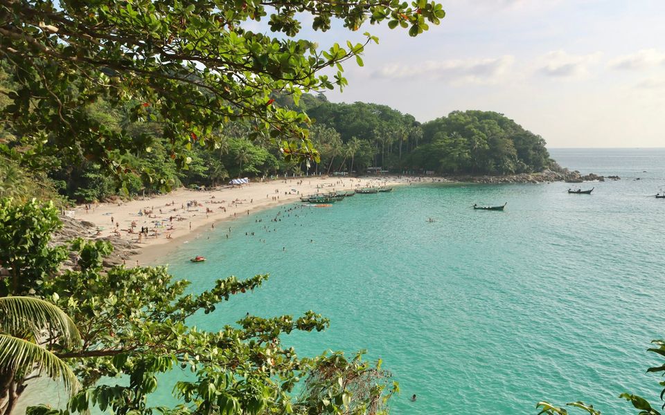 Freedom Beach, Phuket, busy with swimmers and longtail boats