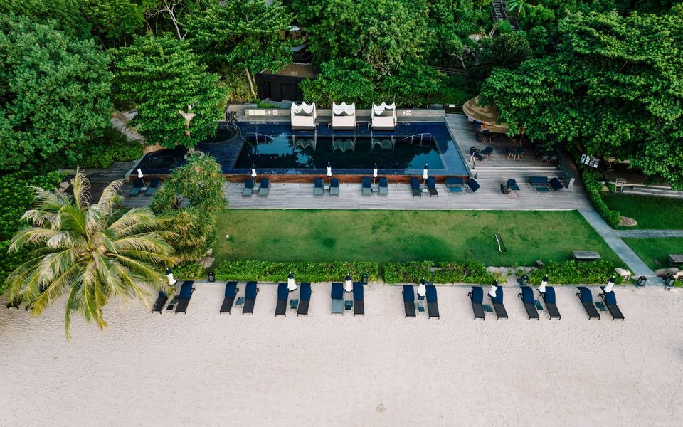 Aerial view of a beachfront resort pool and rows of sun loungers, Koh Samui